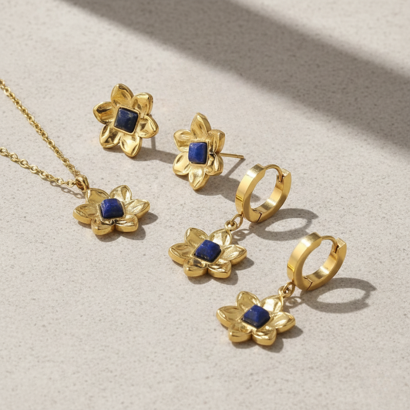 Gold jewelry set with blue stones on a light background