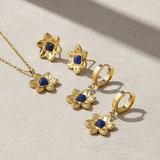 Gold jewelry set with blue stones on a light background