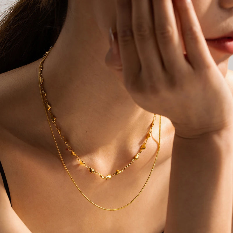 Model wearing Layered Love Necklace in Waterproof 18K Gold-Plated Stainless Steel with heart chocker 37cm and a snake necklace 41.5cm and 5cm extension