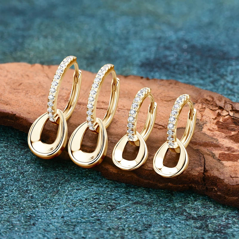 two pairs of Moissanite Hoops Earrings in yellow Gold Plated Silver in two different sizes displayed on a wood background