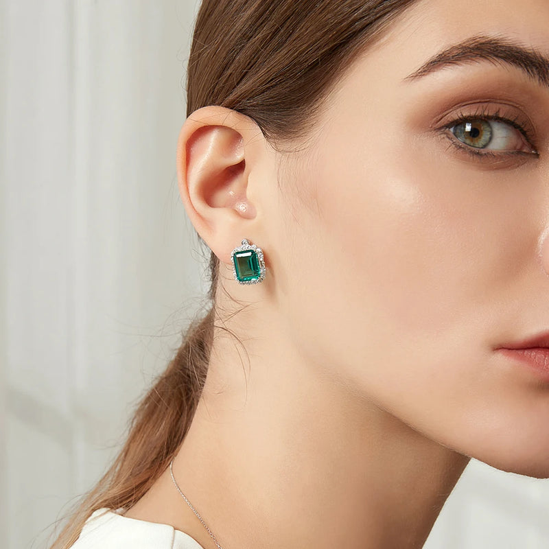 model wearing sterling silver square vintage emerald earrings surrounded in clear stones