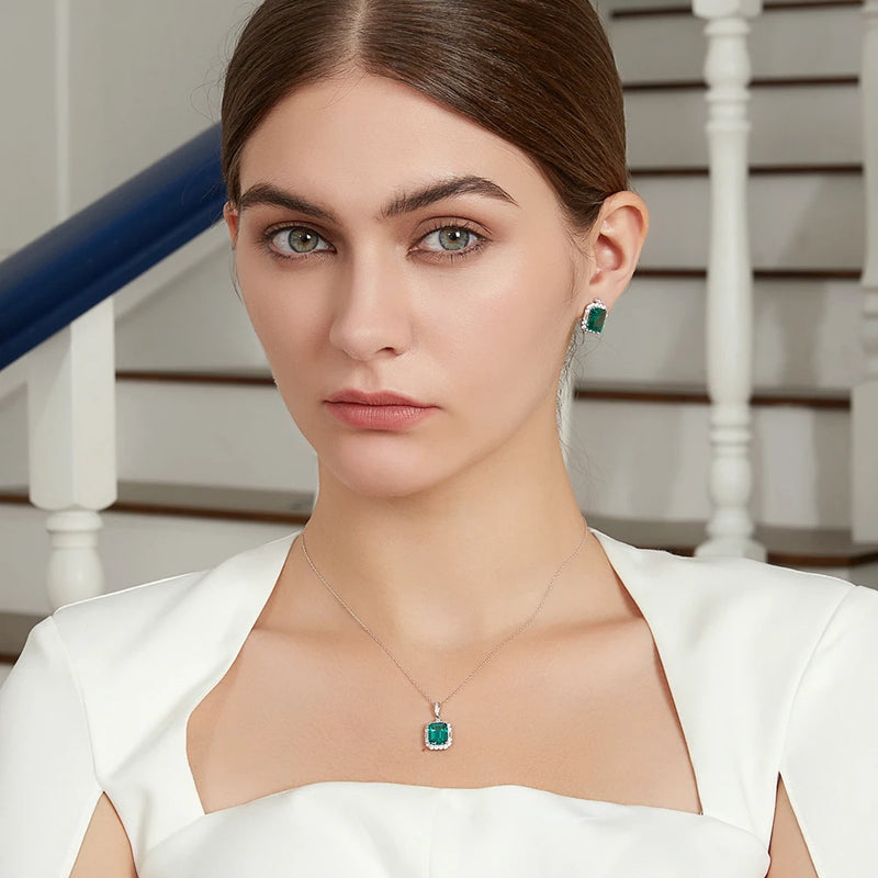 model wearing sterling silver square vintage emerald earrings surrounded in clear stones