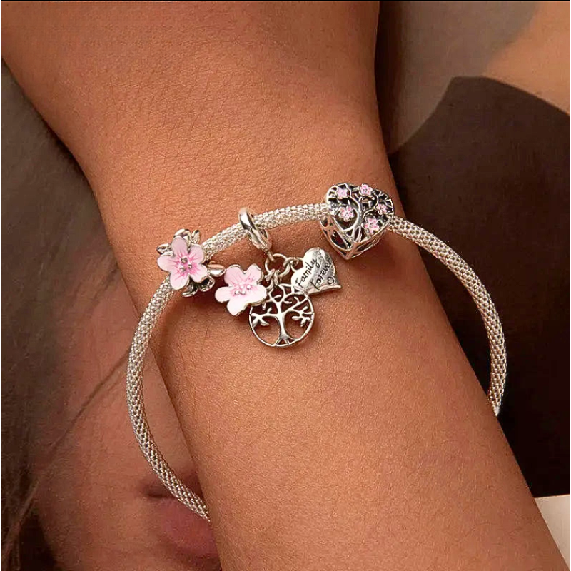 model hand wearing Tree of Life and Pink Flower Charms in Silver