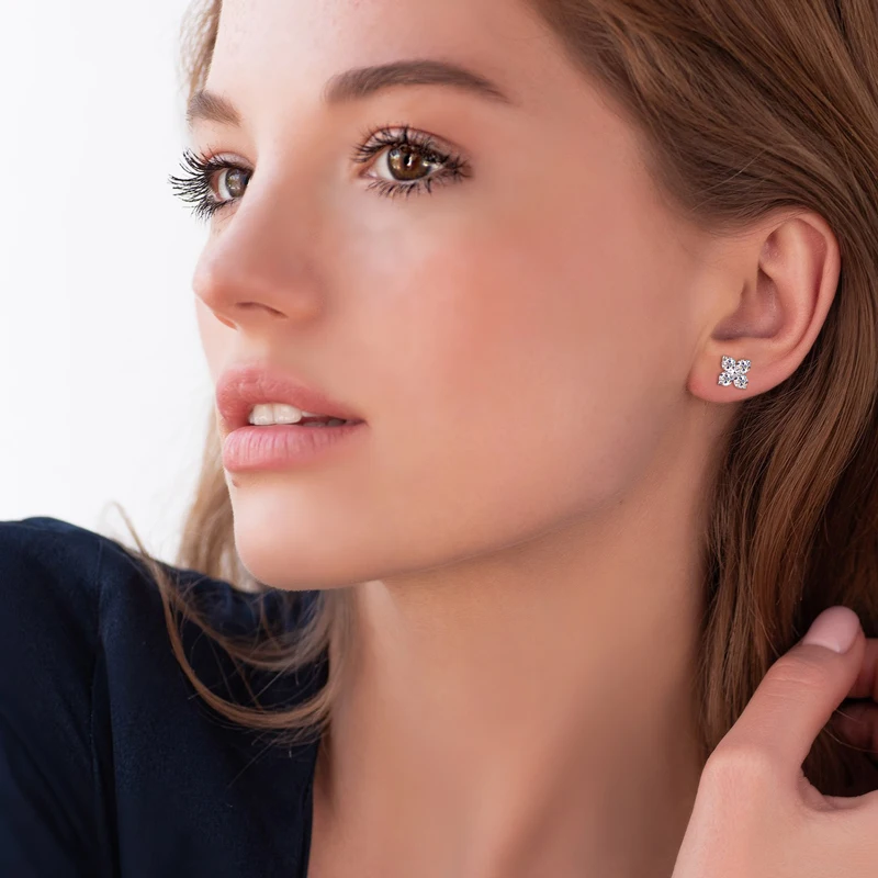 model wearing four leaf clove moissanite earring in white gold plated silver 