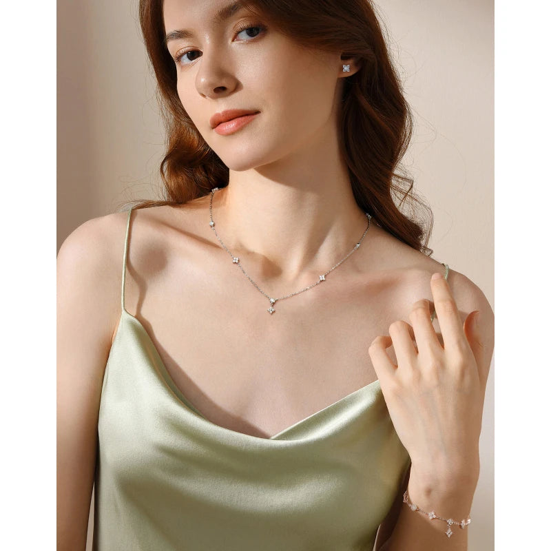 model wearing four leaf clove moissanite earrings necklace and bracelet set in white gold plated silver 