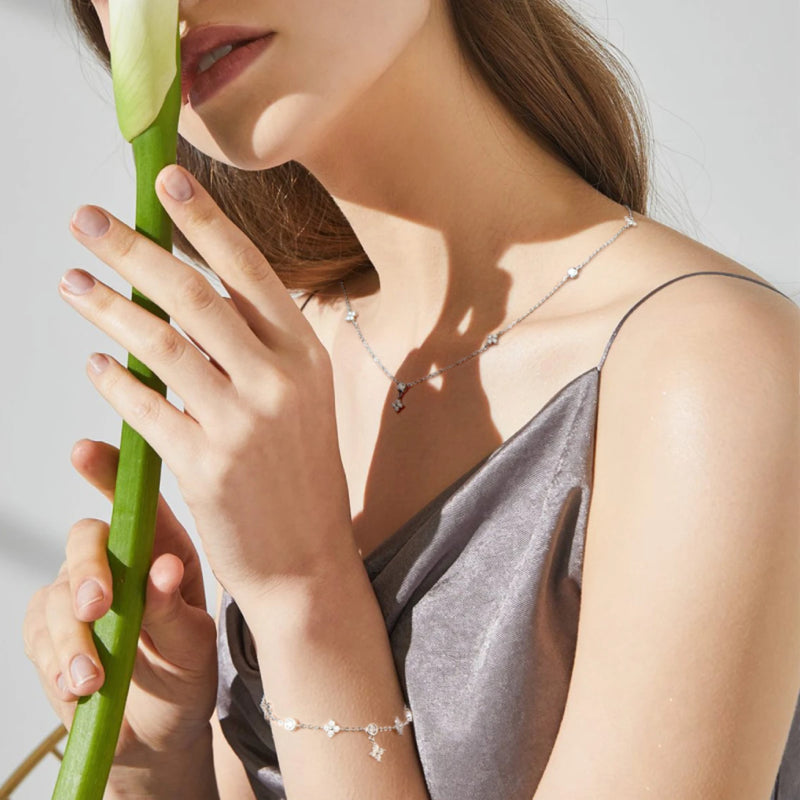 model wearing four leaf clove moissanite necklace and bracelet set in white gold plated silver 