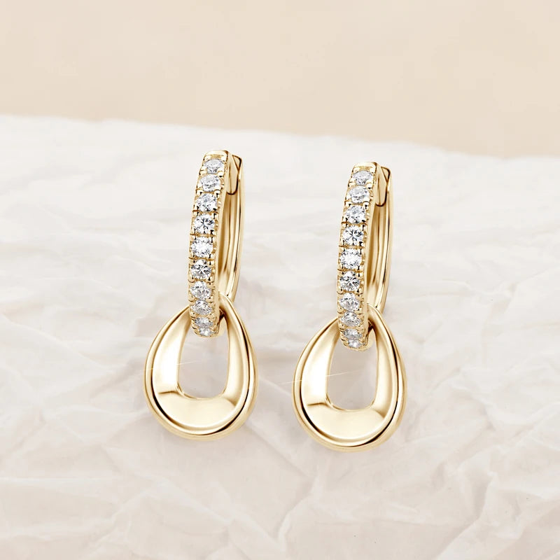 Moissanite Hoops Earrings in Yellow Gold Plated Silver  displayed on a sand color background