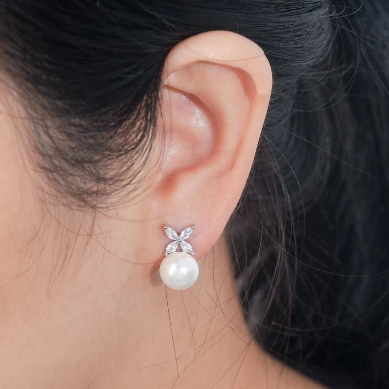 model wearing Pearl Stud Earrings in Silver with clear stone four leaf on top