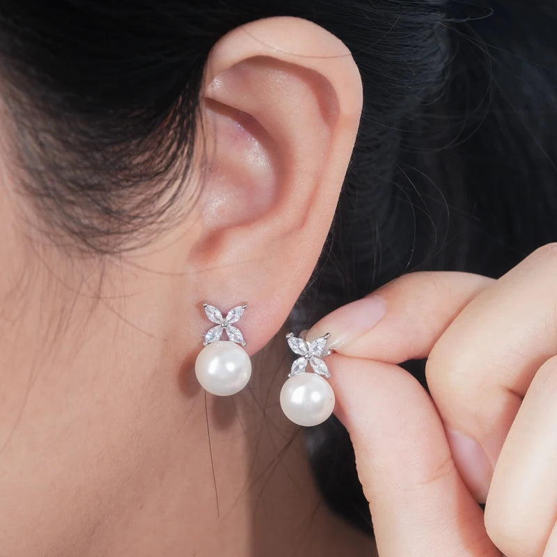 model wearing Pearl Stud Earrings in Silver with clear stone four leaf on top