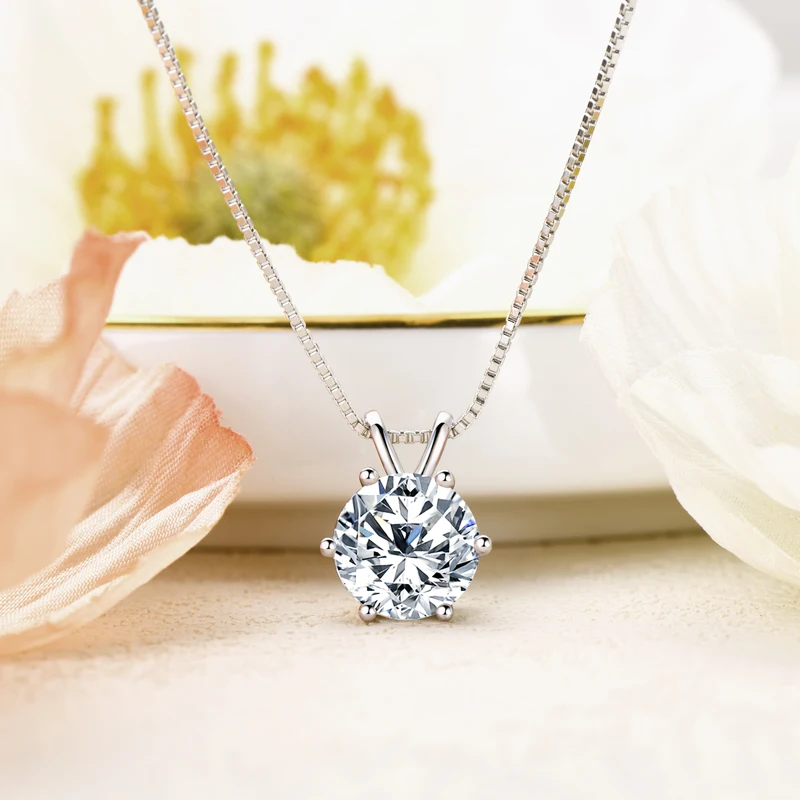 solitaire moissanite  necklace in white gold plated silver displayed on pastel background with flowers