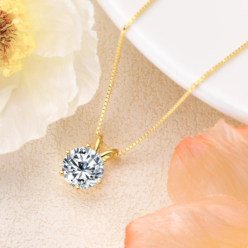 solitaire moissanite  necklace in yellow gold plated silver displayed on pastel background with flowers