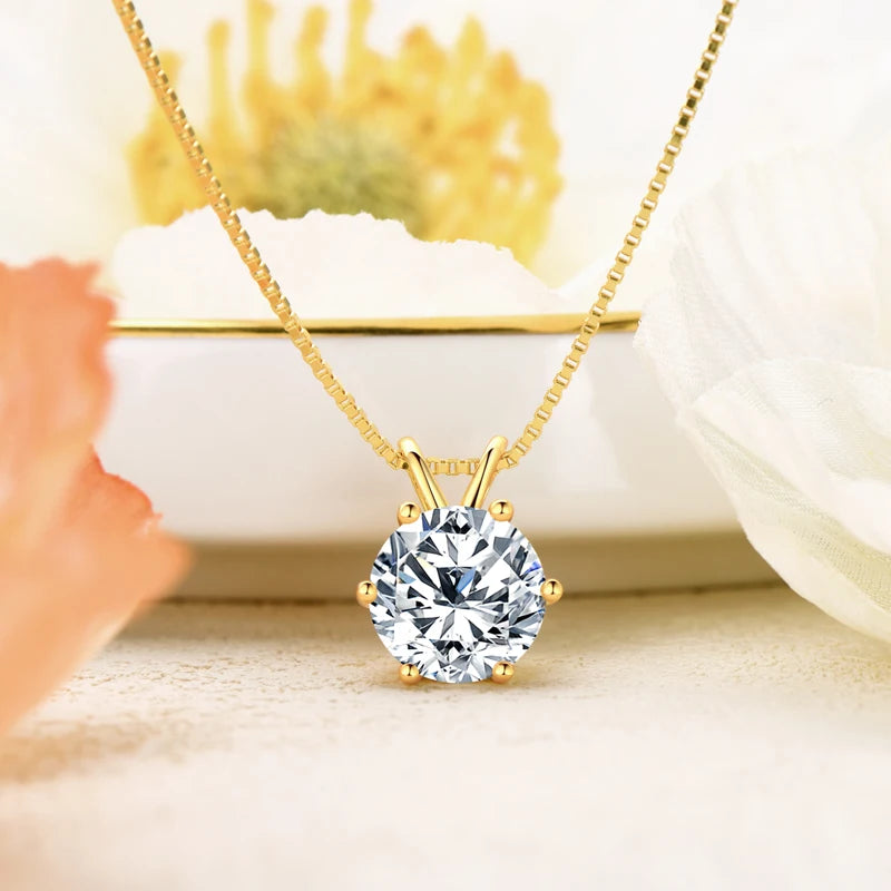 solitaire moissanite  necklace in yellow gold plated silver displayed on pastel background with flowers